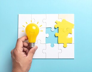 A hand holds a yellow lightbulb above a mostly complete white jigsaw puzzle with a missing yellow piece, suggesting a solution or idea
