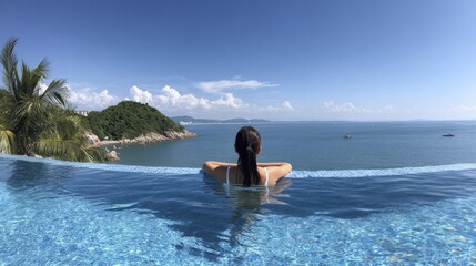Obraz premium Relaxing infinity pool with ocean view under clear blue sky
