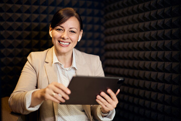 Cheerful Businesswoman Using Tablet During Video Conference in Acoustic Room