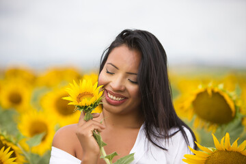 A beautiful mulatto Latin woman with a white shirt brings it close to her face and flirts with a...