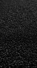 Fototapeta premium Closeup macro shot of black sesame seeds, showing their granular texture and dark color, with a shallow depth of field creating a blurred background