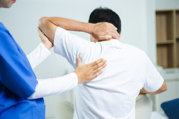 Obraz premium Nurse provides back massage to senior patient in clinic. Perfect for physiotherapy, rehabilitation, aging care, wellness, pain relief, and professional healthcare themes.