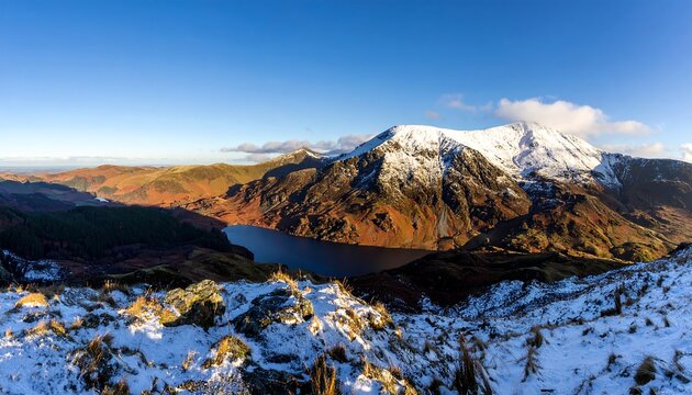 Panoramic mountain view of a snowy peak over a lake at sunrise - Powered by Adobe