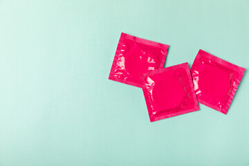 Condoms on a colored background. Colorful fruit-themed condoms in packaging. Safe sex concept....