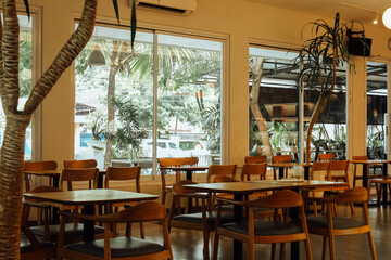 Cozy Warm Light Filled Cafe Interior with Wooden Tables and Chairs