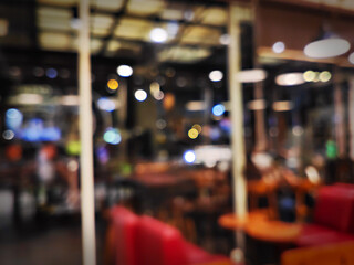 A blurred, Bokeh style image offers an abstract view of a restaurant or cafe interior at night