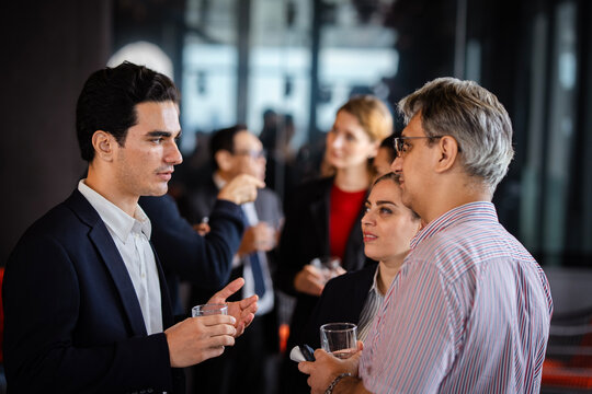 Casual business networking event with professionals interacting, demonstrating company culture, leadership, and modern professional engagement. - Powered by Adobe