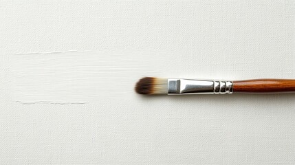 Fototapeta premium Creating texture with a brush on a blank canvas during a painting session in a studio
