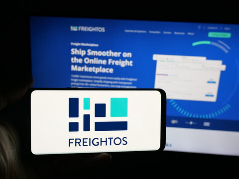 Stuttgart, Germany - 09-25-2025: Person holding smartphone with logo of freight booking company Freightos Ltd. on screen in front of website. Focus on phone display.