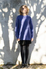 Young person looking up, reflecting in dappled light