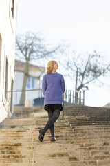 Young woman looking up at sky on steps