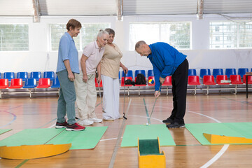 elderly group  plays mini golf for competitions in the sprot hall.  Kidult gaming in the gym....