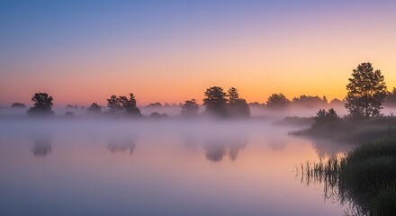Fototapeta premium Tranquil misty lake scene at dawn with trees and colorful sky