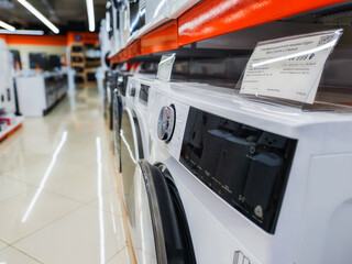 The image shows a retail space, probably a home appliance store. Washing machines are depicted in the first line of the structure.