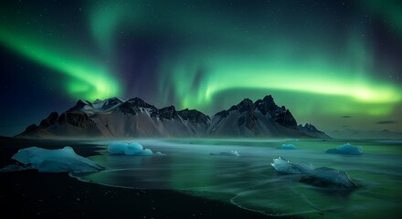 Spectacular aurora borealis display over snow capped mountains and coastal waters