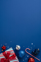 Vibrant vertical blue background with wrapped gifts, candy cane, ornaments, and festive accents...