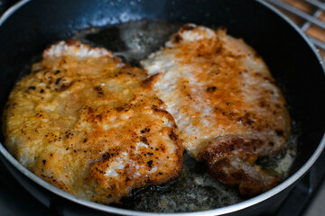 Frying pork chops in hot fat.
