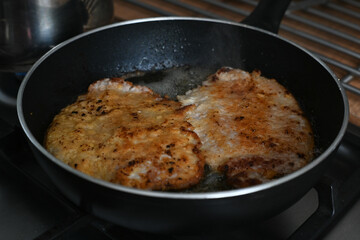 Frying pork chops in hot fat.
