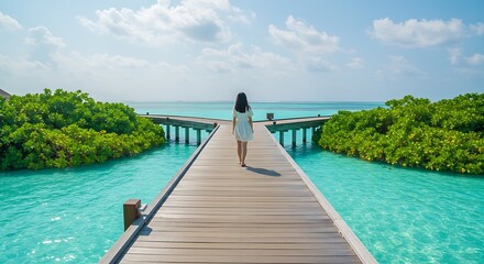 Fototapeta premium Woman walking on wooden bridge over turquoise water in sunny day