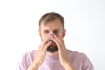 Young man applying cleansing pore strip to nose for skincare treatment, concept of personal care and grooming
