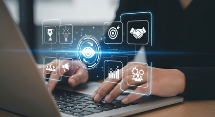 Business person typing on a laptop with a digital overlay of business strategy icons and the core concept of vision
