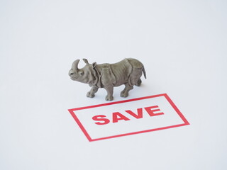 Mini toy of action figure at outdoor with blurred background. Business photography concept design. Minifigure of Rhino character hold SAVE ANIMAL poster banner. © awstoys