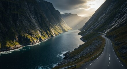 Scenic mountain landscape with a winding road and a tranquil lake under dramatic cloudy skies
