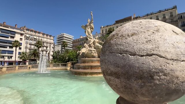 Lateral tracking shot with a foreground perspective of the monumental limestone water fountain and statues at Place de la Libert&eacute; (Liberty Square) in Toulon, France.
