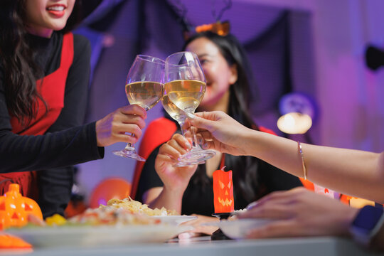 Friends toasting with drinks celebrating halloween party at home