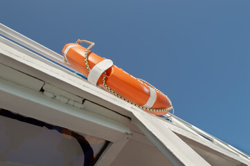 An orange lifebuoy hangs on a ship