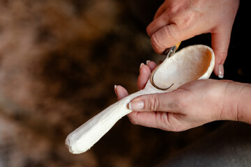 Female hands carving wooden spoon