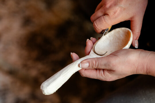 Female hands carving wooden spoon