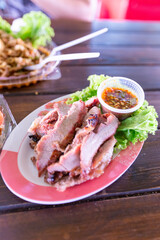 A delicious grilled pork steak meal with fresh salad and roasted vegetables on a white plate