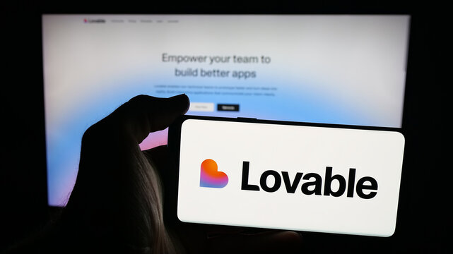 Stuttgart, Germany - 09-25-2025: Person holding mobile phone with logo of Swedish ai software company Lovable Labs Inc. on screen in front of web page. Focus on phone display.