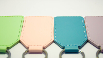 Set of colorful rectangular leather keychains with metal rings isolated on a white background. Concept of personalized accessories, engraving blanks, handmade crafts, and custom gift ideas