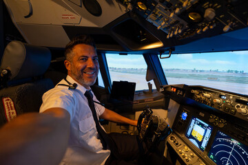 Commercial pilot smiling taking selfie in flight simulator cockpit