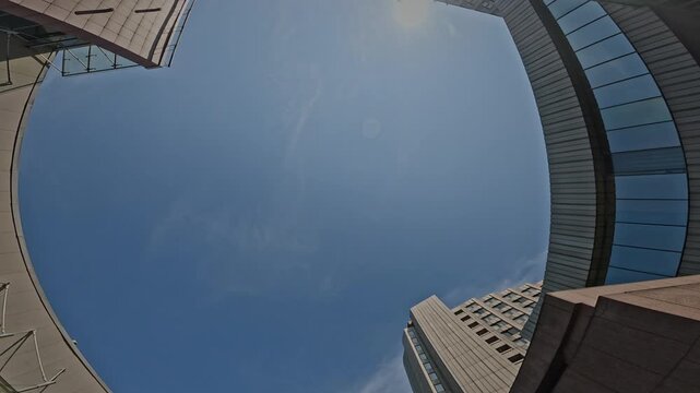 Bottom view POV shot of acrobatic young Caucasian guy performing spectacular backflip practicing parkour tricks in urban environment on sunny day outdoors - Powered by Adobe