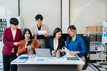 Startup asian business team collaborating in modern office, reviewing project strategy, sharing ideas, and building success through teamwork and planning.