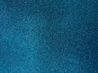 Close-up of sparkling blue glitter surface — abstract festive texture with shimmering light reflections and emotional decorative accent