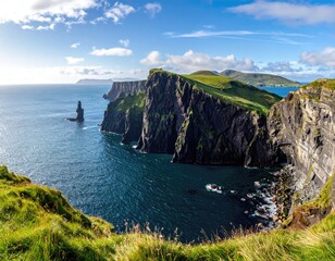 Dramatic coastal scenery with towering, dark cliffs plunging into a vibrant blue ocean