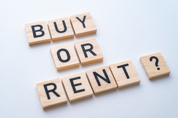 Buy or rent text composed with wooden alphabet, on a white background. Option between renting and buying.