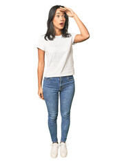 Fototapeta premium Full body shot of Latina in studio looking far away keeping hand on forehead.
