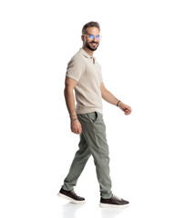 side view of happy casual guy with glasses smiling and stepping forward