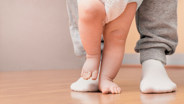 The baby takes his first steps with his dad