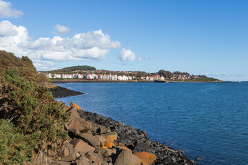 A tranquil view of the Dalgety Bay coastline, Fife, Scotland, featuring the calm waters meeting the rocky shore. The image captures the peaceful ambience of this Scottish coastal town.