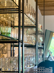 Large shelf with various glasses and glasses on the wall of a cafe. Bar and restaurant tableware