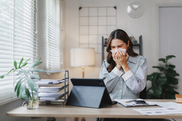 Businesswoman sneezing while working from home office