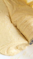 Smooth cupcake batter with spatula in mixing bowl closeup