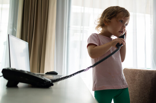 Little girl making a phone call in home office setting - Powered by Adobe