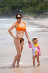 Mother and daughter enjoying tropical beach vacation